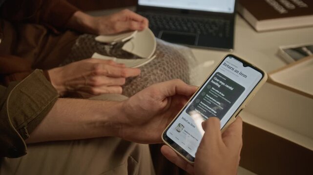Cropped shot of unrecognizable couple inspecting broken porcelain plate and requesting product return via smartphone app. Ideal for e-commerce customer support, delivery insurance