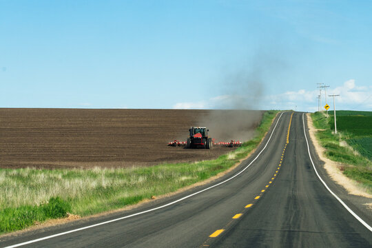 Red Tractor Plowing Prairie Field