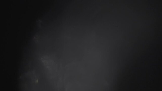 Realistic film light leak and optical glass refraction overlay on a black background. Features gentle bokeh shimmer for video transitions, title backgrounds, and cinematic post-production effects.