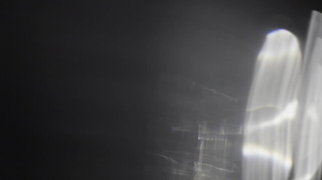 Abstract light leak visual effect showing soft rainbow prism refraction and luminous circular flare on black. High-resolution overlay stock footage for modern motion design.