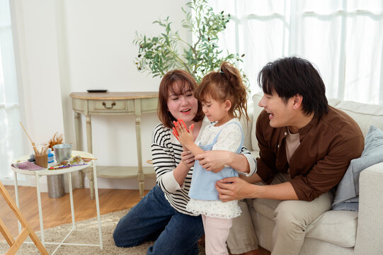 Family Painting Together at Home With Young Girl Working on Her Artwork