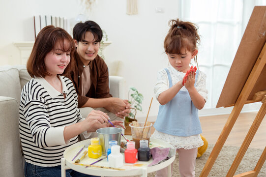 Family Painting Together at Home With Young Girl Working on Her Artwork