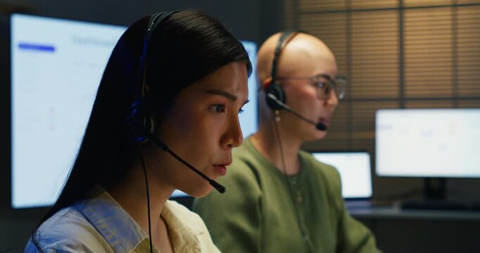 Two Asian women having a meeting in an office setting. Dedicated staff members sharing information, showing togetherness, and collaborating on a marketing and contact project.