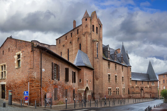 Street level view of Berbie Palace in Albi, France. Medieval fortress architecture under cloudy overcast sky