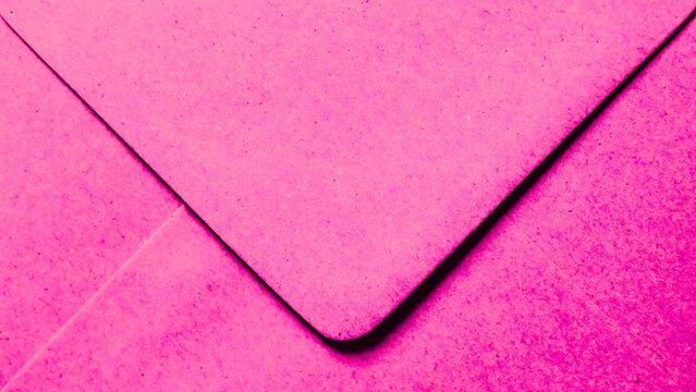 Close up view of bright pink envelope flap featuring paper fiber textures