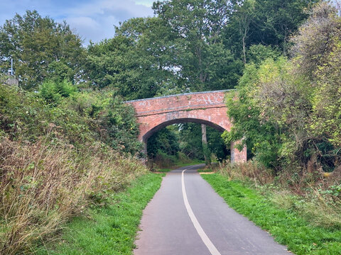 Old Red Brick Railway Bridge over Paved Countryside Walking Trail and Cycle Path