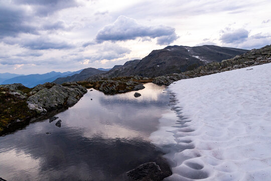 A beautiful high altitude mountain lake and snow. A seasonal scenery of Hercal valley in World Heritage area in Western Norway.
