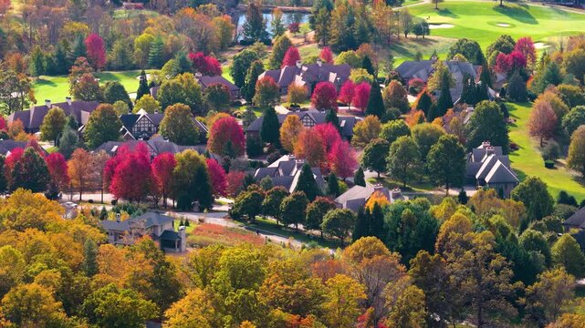 Aerial panorama of suburban homes on wooded hills near Asheville during fall season. Colorful mountain forests create picturesque residential landscape.