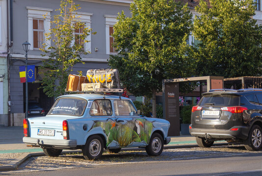 Vintage Trabant with rooftop suitcases and tropical artwork in Cluj-Napoca - August 14, 2026