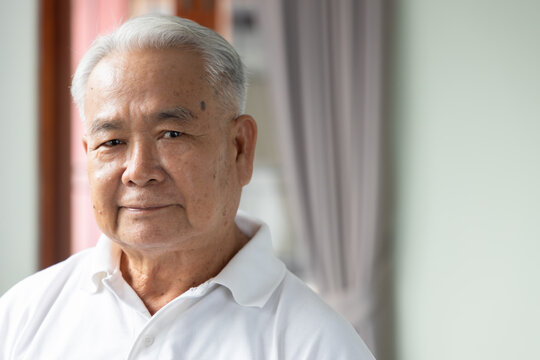 southeast asian senior man face portrait with neutral mood and emotionless expression, indoor scene