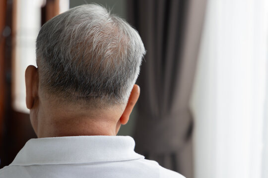 Back of head portrait of old age senior Asian man, with gray or silver hair as a sign of aging, concept of silver generation hair color change, aging process, indoor home scene, natural window light