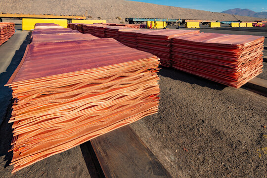 Refined copper cathodes arranged in high stacks at an industrial copper mine in Chile, prepared for dispatch and transport by train.