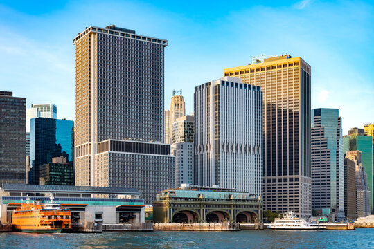 The ferry piers of downtown Manhattan in New York City on the East River, surrounded by the towering Wall Street financial district buildings.