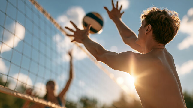 Young shirtless man reaching for volleyball over net during outdoor game