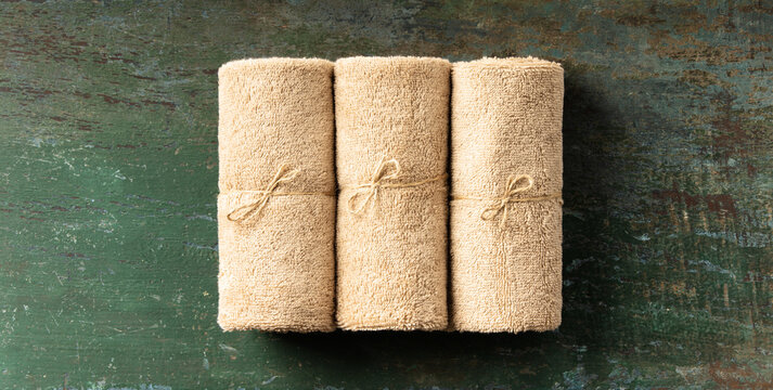 Rolled Natural Towels on Rustic Surface for Spa or Wellness Concept