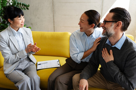 Happy couple reacting positively while talking with a real estate agent after viewing a property, excited about finding their potential new home