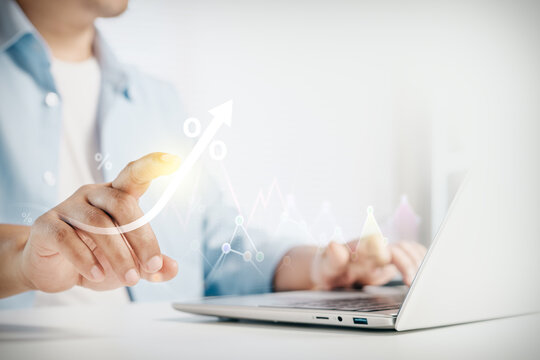 Businessman touching virtual graphic of percentage growth chart and financial data while working on laptop, concept of economic progress, investment return, profit, and digital business.
