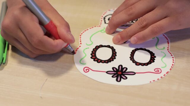 Adding decorative details to a handmade Day of the Dead paper skull