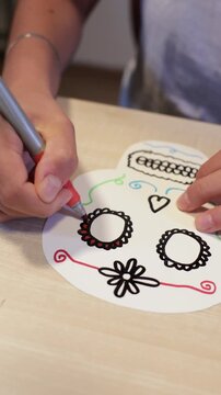 Coloring a paper skull decoration for Day of the Dead