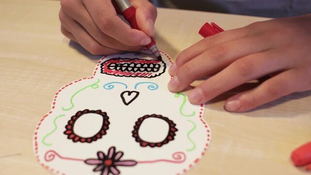 Adding red details to the mouth of a handmade Day of the Dead skull