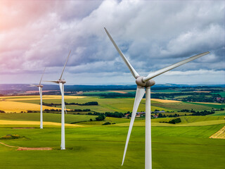 Obraz premium Wind turbines generating renewable green energy and electricity in an open landscape, modern power technology infrastructure for sustainable energy production and clean environmental power systems