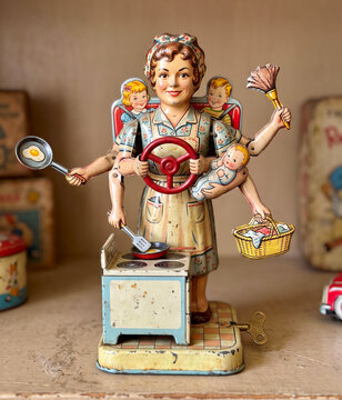whimsical, vintage-style multi-tasking mother tin wind-up toy featuring a woman with multiple arms cooking, cleaning, and caring for children