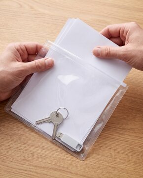 Hands packing emergency documents into waterproof pouch