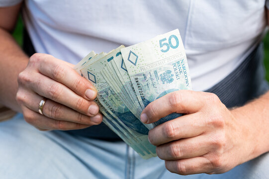 Male Hands Fan Out Polish Zloty Currency Banknotes Stack for Financial Success and Savings