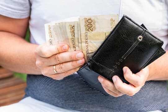 Male Hands Counting High Value Polish Zloty Banknotes in Black Leather Wallet for Finance