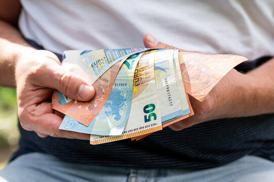 Close up of Man Hands Holding Fan of Euro Currency Notes for European Economy and Savings Concept