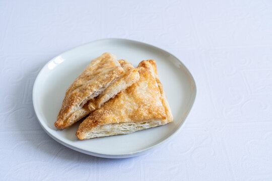 Apple turnovers on a plate with a white tile surface 