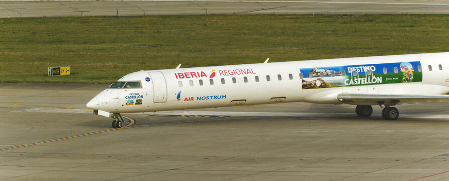 Geneva, Switzerland - August 27, 2026 : sign and logo on a Mitsubishi CRJ-1000 of Iberia Regional Air Nostrum on the runway of Geneva Airport