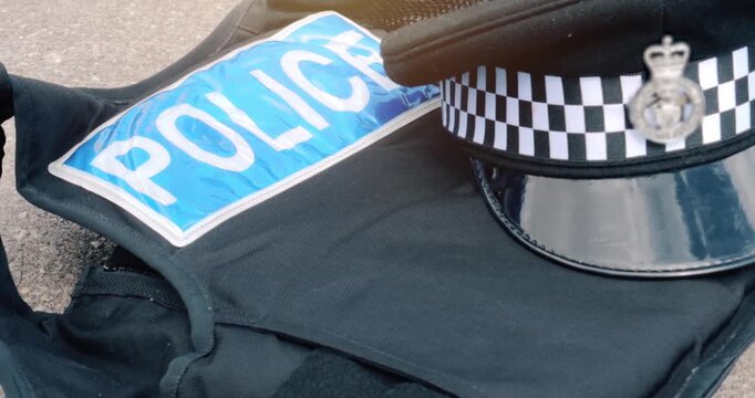 Police officer uniform and Police officer uniform &ndash; UK emergency services law enforcement policeman hat and vest outfit.