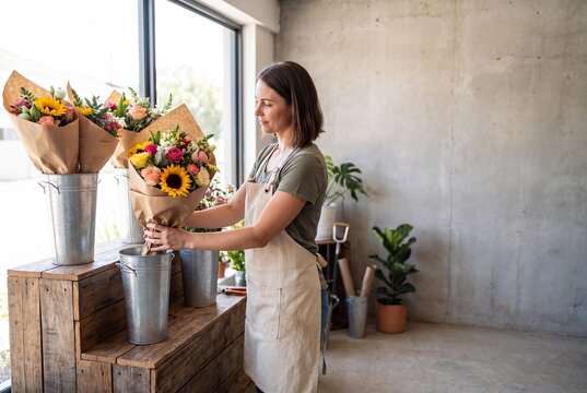 Florist putting flower bunch into metal container