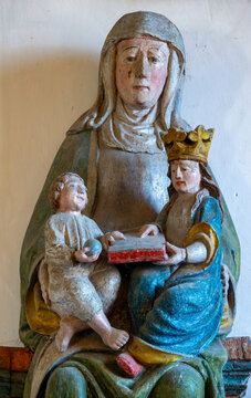A polychrome wooden statue depicts Saint Anne sitting with the crowned Virgin Mary and Jesus.