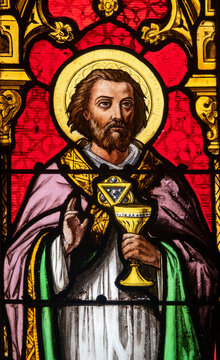 Saint K&eacute;mo, Breton priest holding a Eucharistic chalice in a stained‑glass window.