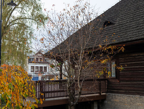 Historic timber log house with wooden veranda, lace-curtained window and weathered shingle roof in Sucha Beskidzka. Authentic vernacular architecture for cultural heritage, traditional craftsmanship, 
