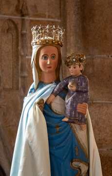 A painted wooden statue depicts the crowned Virgin Mary holding the crowned infant Jesus carrying an orb.