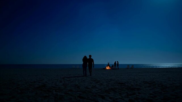 Two silhouetted people hold hands and walk away across a dark sandy beach toward a glowing bonfire, with calm sea horizon, distant figures, and deep blue evening sky