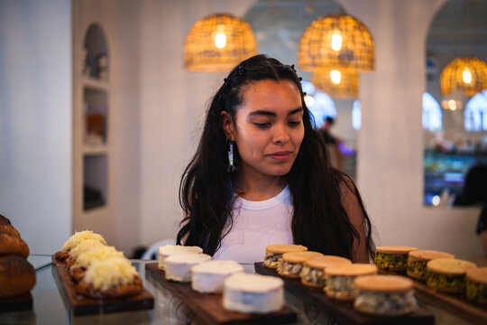 Mujer observando la pasteler&iacute;a en una cafeter&iacute;a