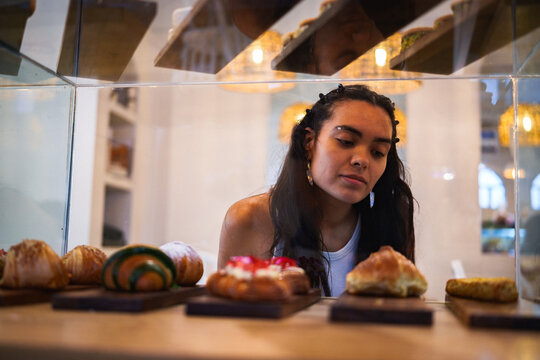 Mujer observando la pasteler&iacute;a en una cafeter&iacute;a