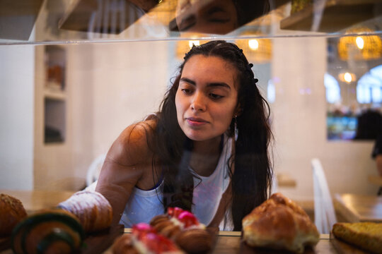 Mujer observando la pasteler&iacute;a en una cafeter&iacute;a
