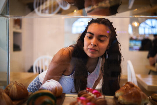 Mujer observando la pasteler&iacute;a en una cafeter&iacute;a