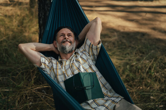 Mature man relaxing in hammock enjoying nature peace