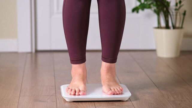 Woman feet standing barefoot on digital bathroom scale at home. Weight loss control and diet concept. Healthy lifestyle fitness monitoring and body mass management for wellness