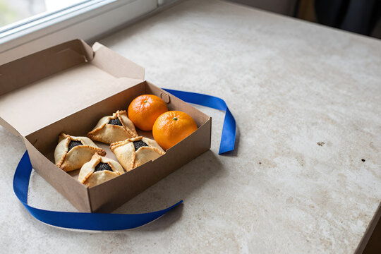Purim food gift box with hamantaschen and mandarins