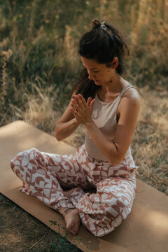 Woman meditating in nature practicing yoga namaste mudra