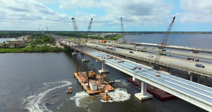 Hardhat workers on American highway bridge road under construction. Adding new lanes to bridge crossing. Development of traffic infrastructure.