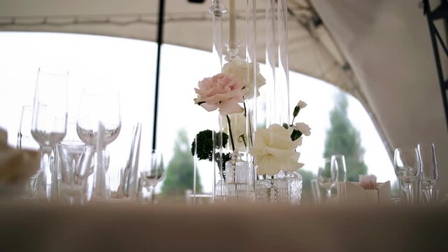 On the festive table, there is a vase with flowers and other decorations. Side‑view shot.