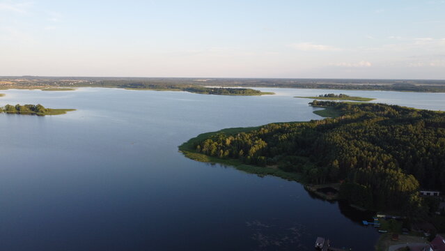 Aerial view of a curving lake shoreline and forested islands 